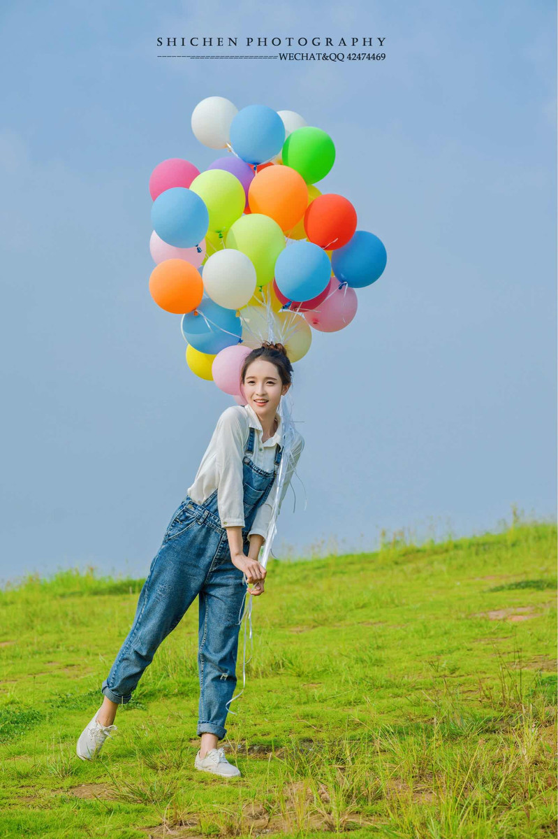 玩气球的牛仔裤背带女孩