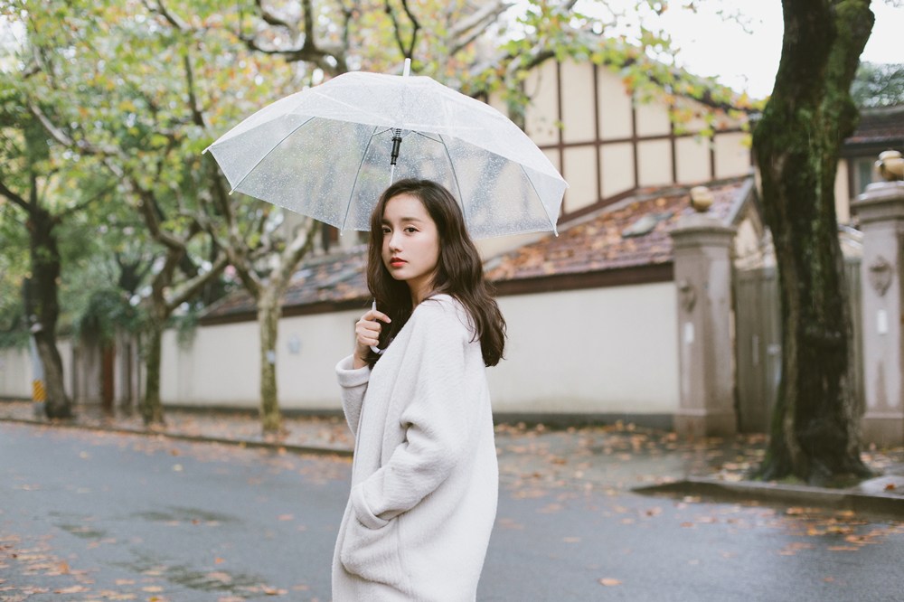 吕一雨中漫步眼神清澈淡雅妆容街拍图片